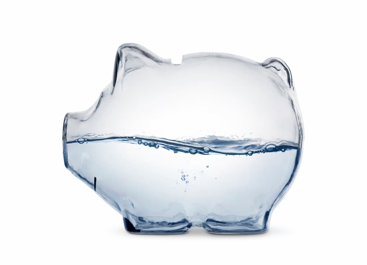Transparent piggy bank half filled with water