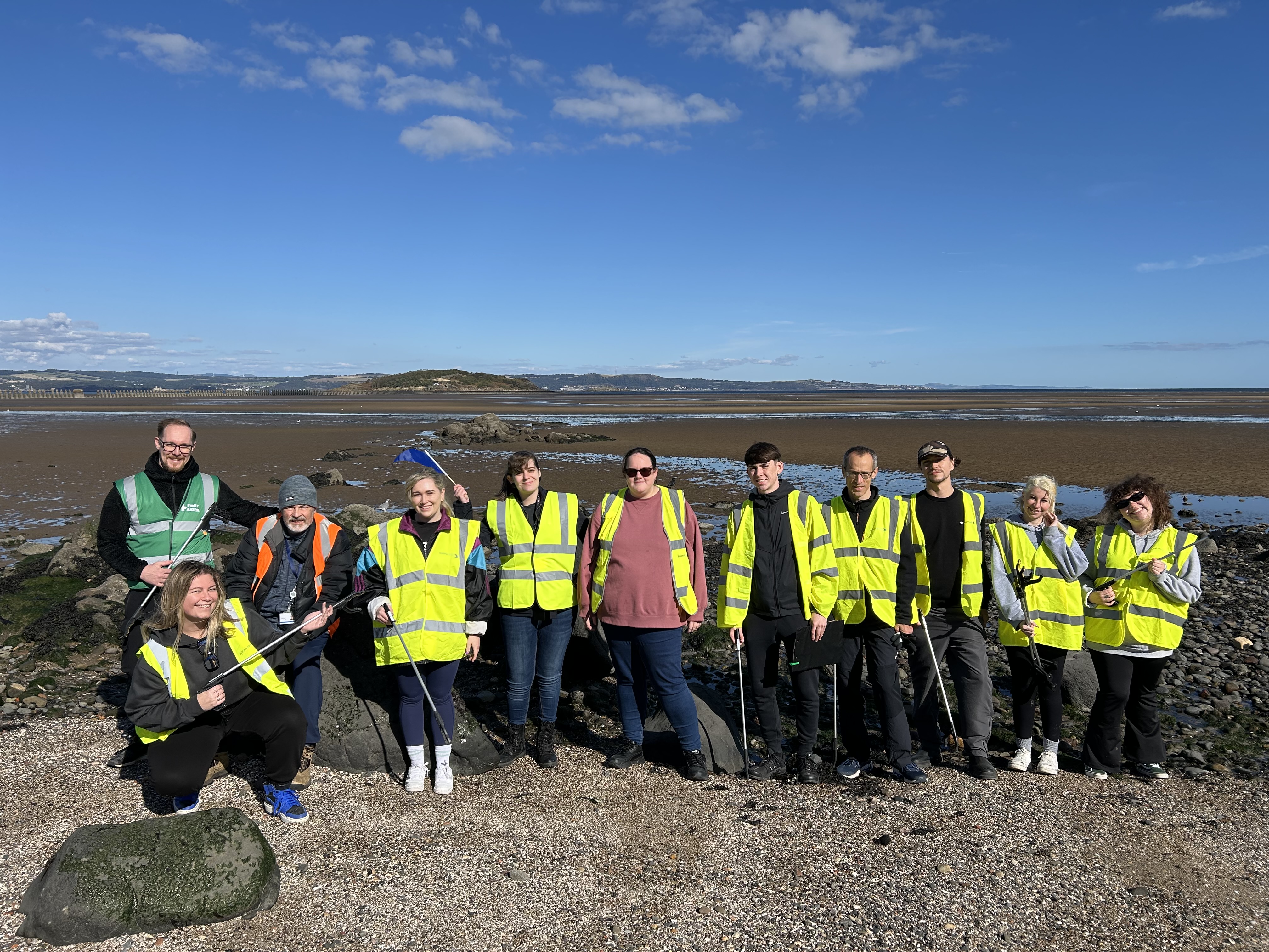 People in high-vis vests doing a beach clean
