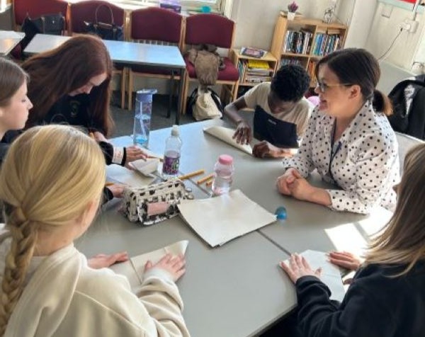 Primary school students around a table with volunteer