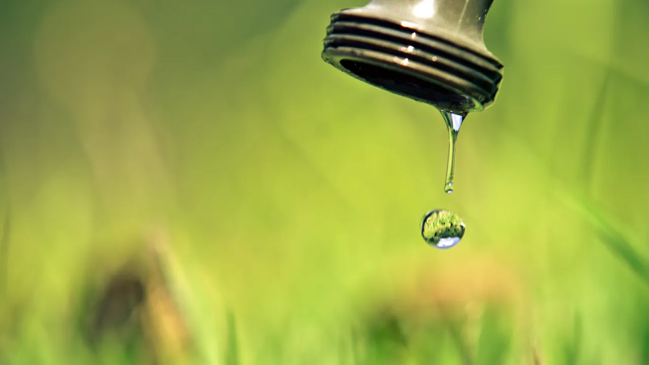 A water droplet falling from an outdoor tap