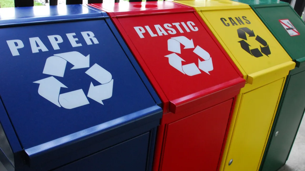 Colour-coded recycling bins for paper, plastic and cans.