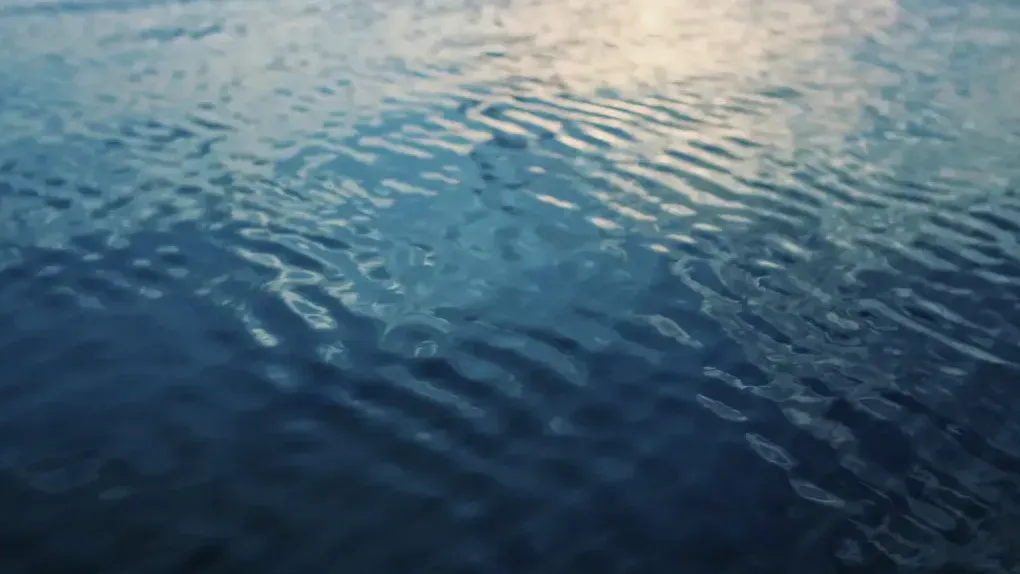 Rippling water with soft waves reflecting the light from the sky.