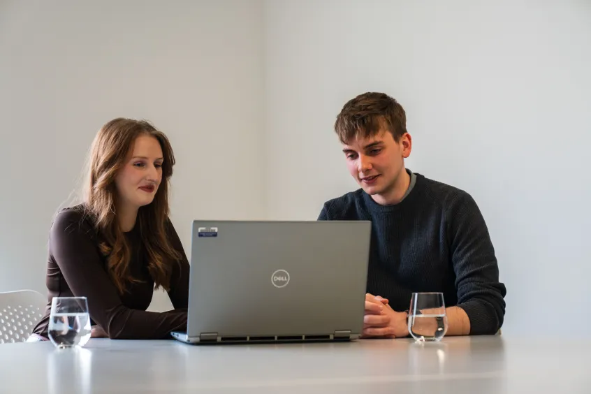 Woman and young man looking at laptop together