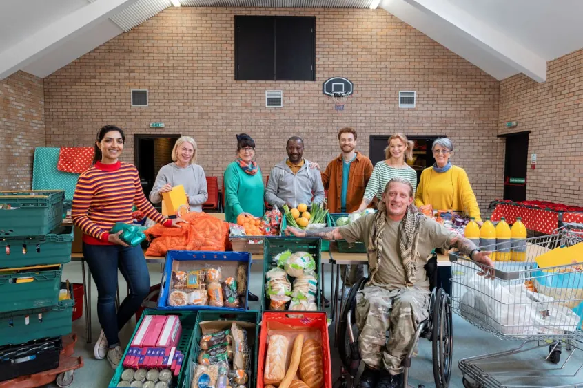 Group of charity workers at a food bank with crates of food