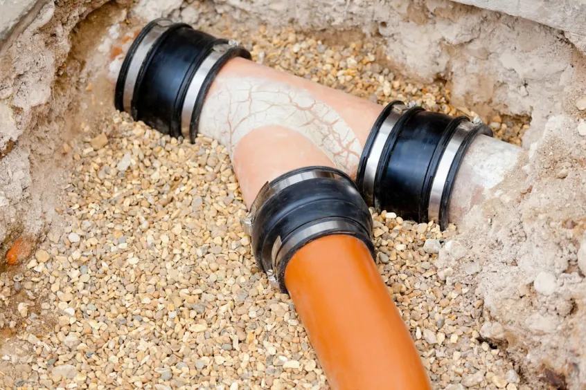 Junction of clay sewage pipe surrounded by gravel