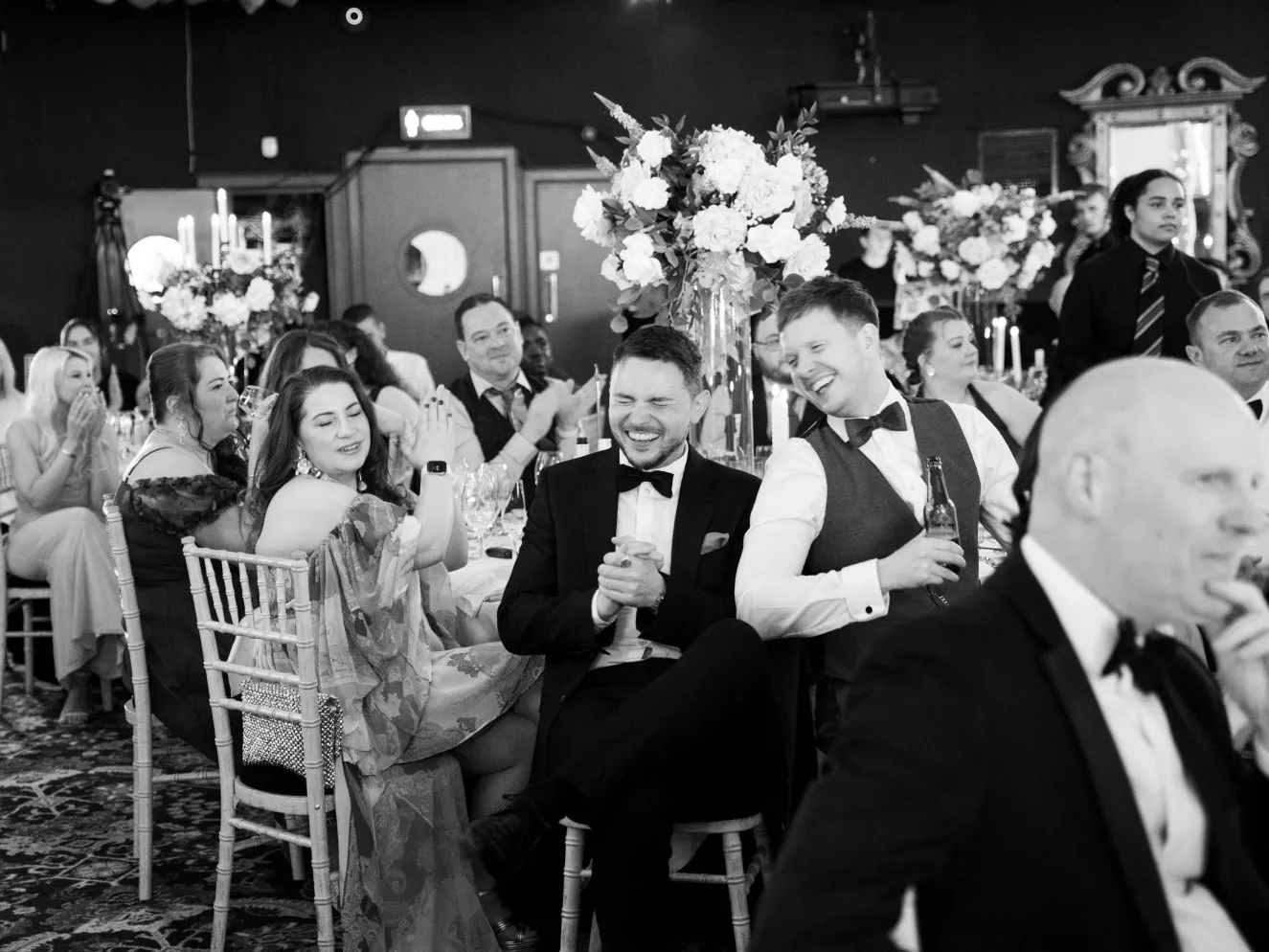 Black & white shot of colleagues laughing and smiling at dinner tables at Business Stream Awards Night