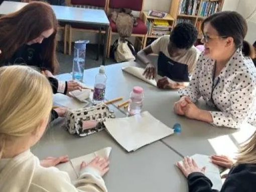 Primary school students around a table with volunteer