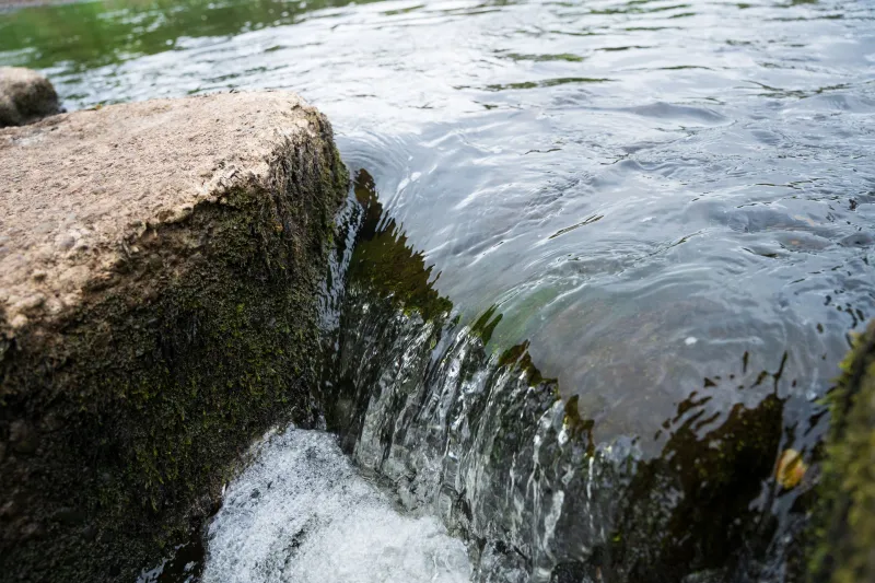 Close-up of river water flowing round a rock