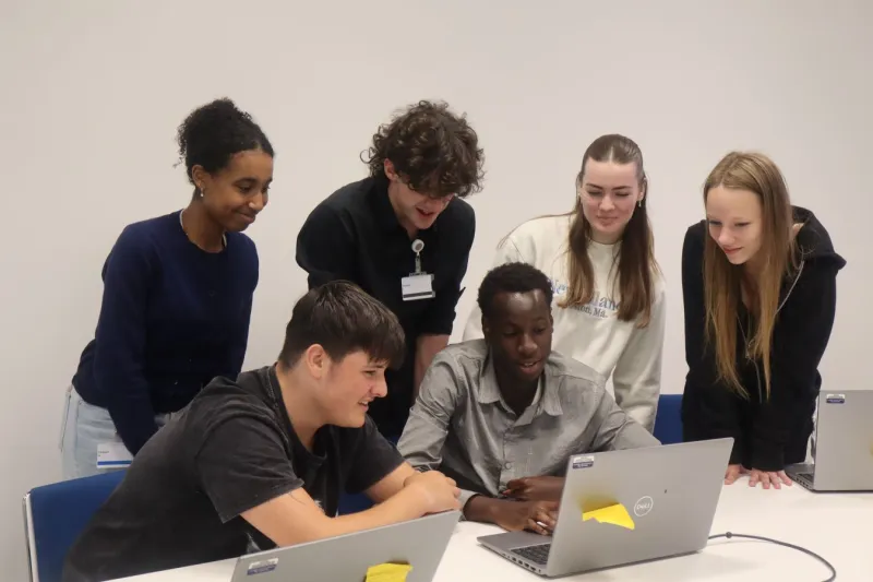 Six young people looking at laptop