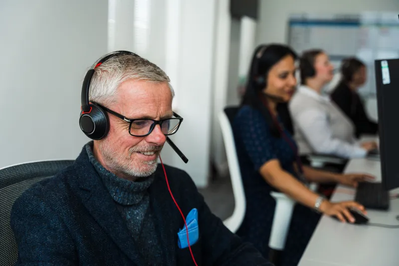 Man wearing headphones in call centre setting