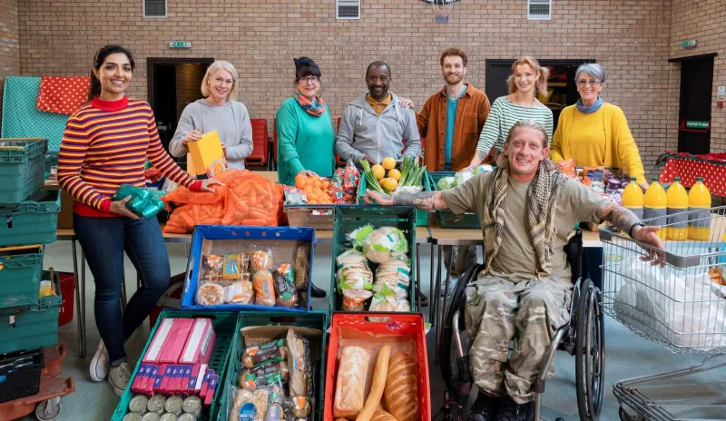 Group of charity workers at a food bank with crates of food