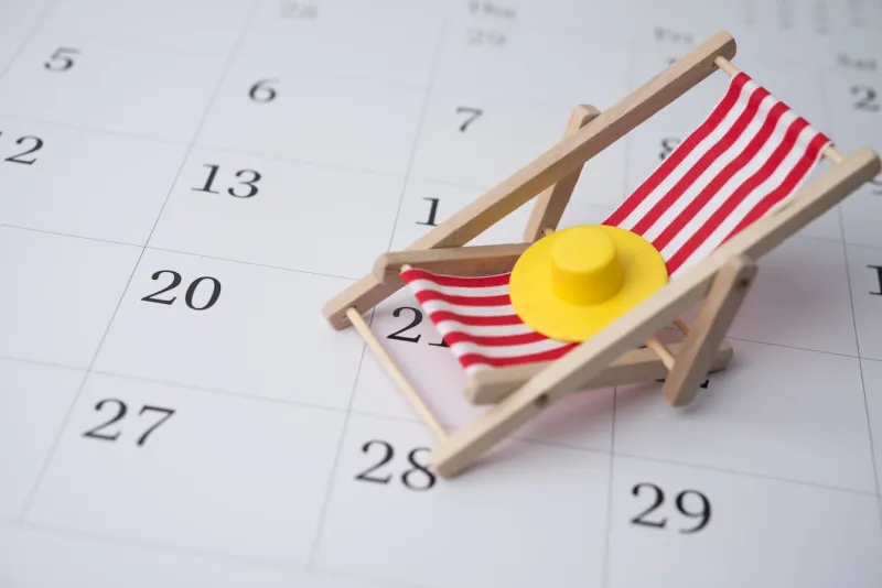 Planner-style calendar with a model deck chair and sun hat on it representing annual leave