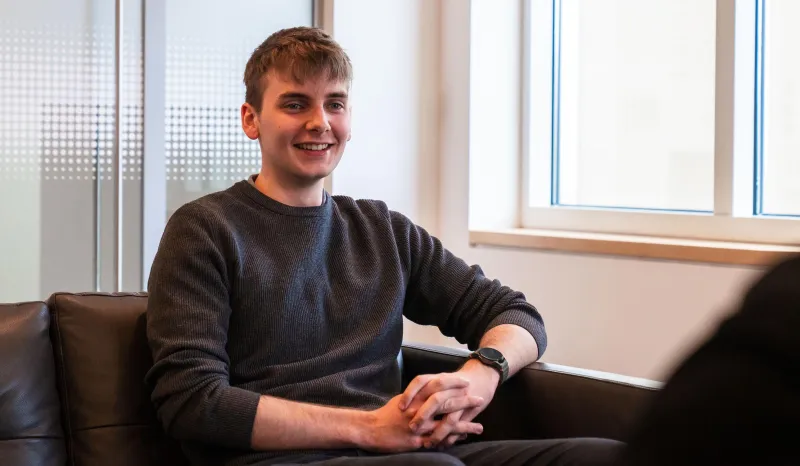 Young man sitting on sofa and smiling