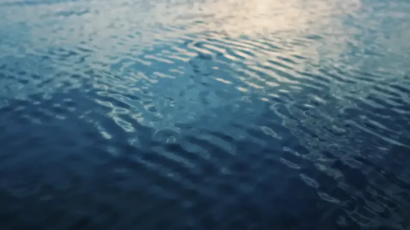 Rippling water with soft waves reflecting the light from the sky.