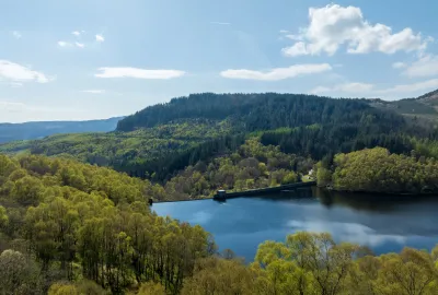 Glen Finglas reservoir in foreground with hills and forest in background.