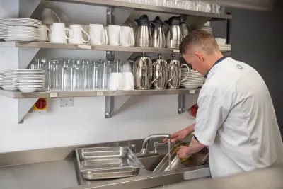 Man washing equipment in a commercial kitchen